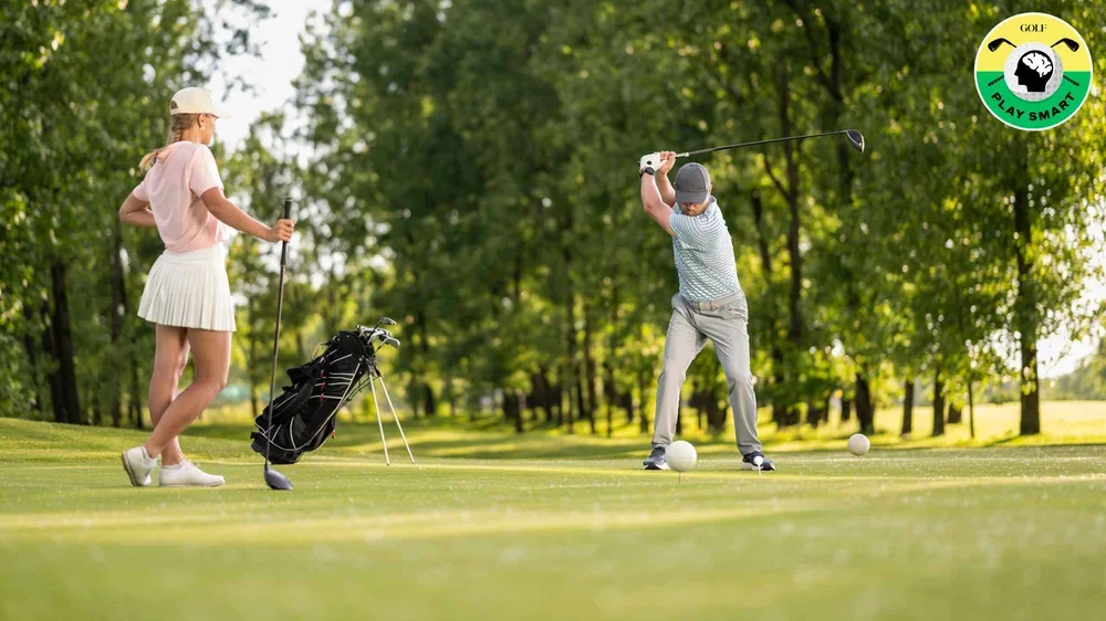 golfer swings while another golfer looks on